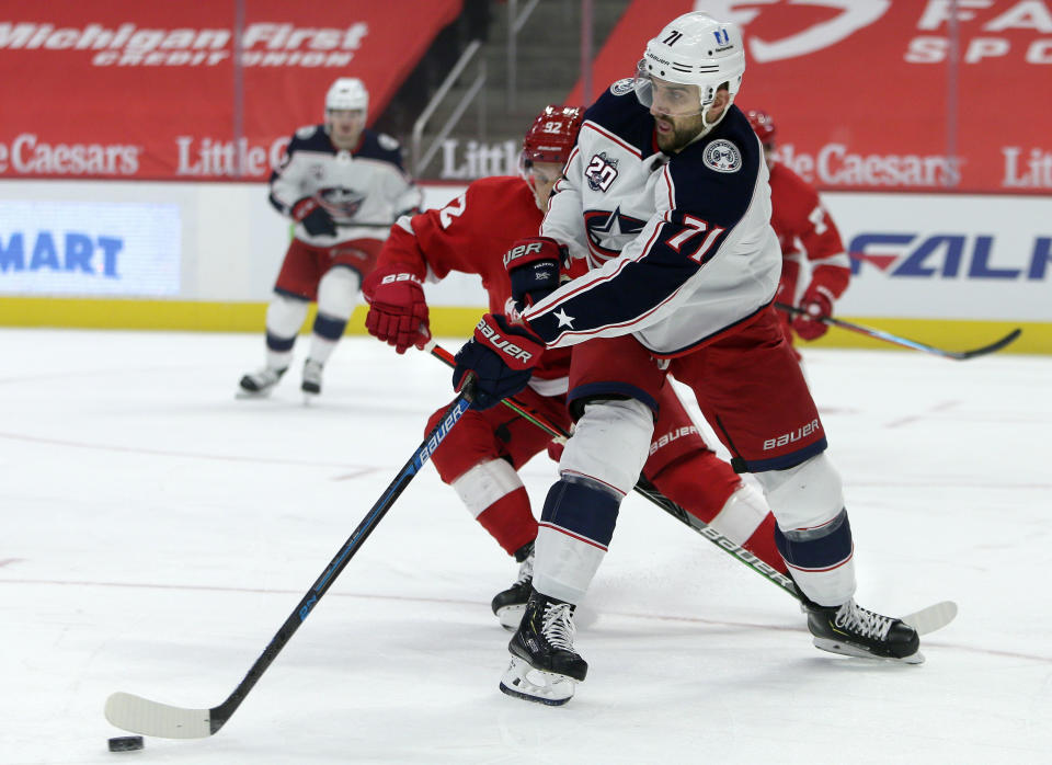 Columbus Blue Jackets left wing Nick Foligno (71) clears the puck against Detroit Red Wings center Vladislav Namestnikov (92) during the first period of an NHL hockey game Tuesday, Jan. 19, 2021, in Detroit. (AP Photo/Duane Burleson)
