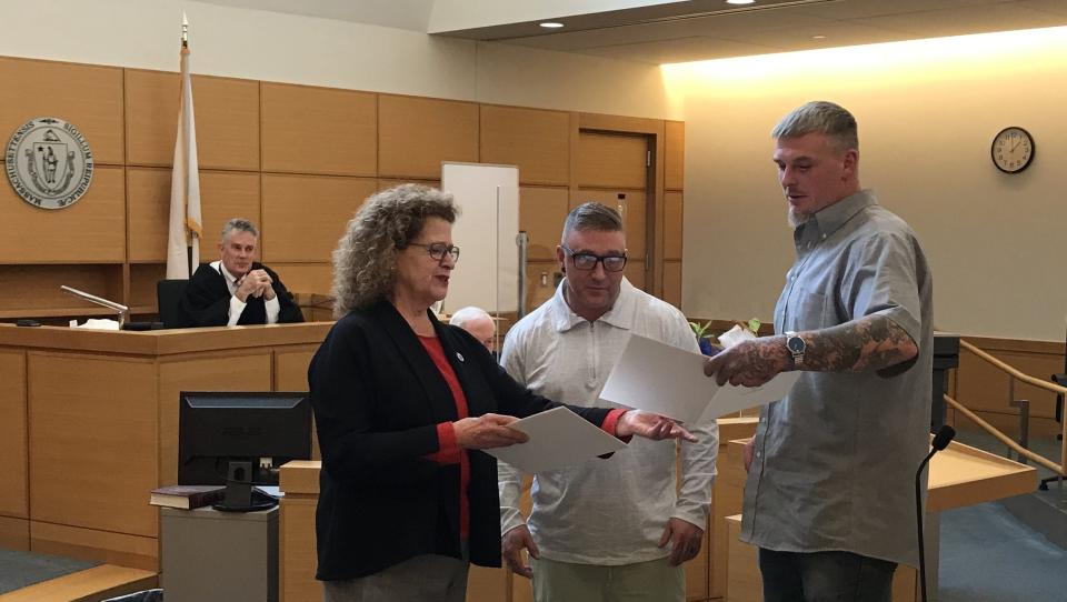 State Rep. Carol Doherty, D-Taunton, left, presents graduation certificates to Taunton Recovery Court participants Thomas Halpin, center, and David Engler during a commencement ceremony on Wednesday, Nov. 30, 2022, at Taunton District Court.
