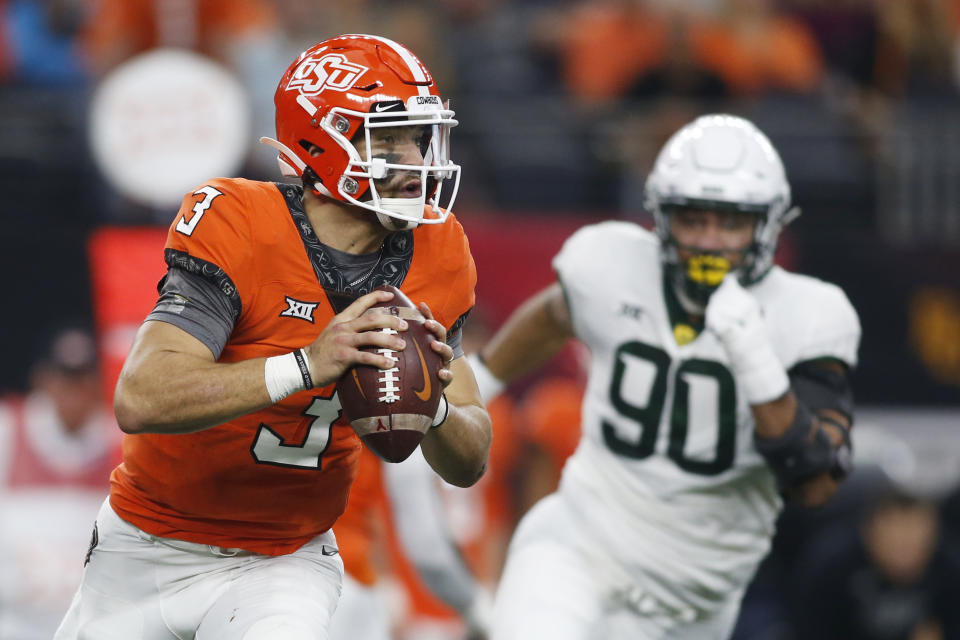 FILE - Oklahoma State quarterback Spencer Sanders (3) rolls out to pass while chased by Baylor defensive lineman TJ Franklin (90) in the first half of an NCAA college football game for the Big 12 Conference championship in Arlington, Texas, Saturday, Dec. 4, 2021. Sanders has made a steady climb in four years at Stillwater and gets a chance to cap his season in a major way at the New Year's Day Fiesta Bowl. (AP Photo/Tim Heitman, File)