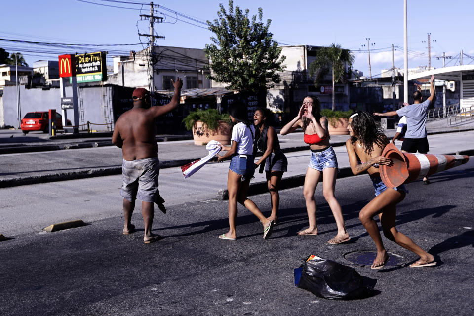 Residents protest against police near the Getulio Vargas Hospital after a police raid on the Vila Cruzeiro favela in Rio de Janeiro, Brazil, Tuesday, May 24, 2022. Police raided the favela before dawn Tuesday in an operation that prompted a fierce firefight and state officials said at least 10 people died. (AP Photo/Bruna Prado)