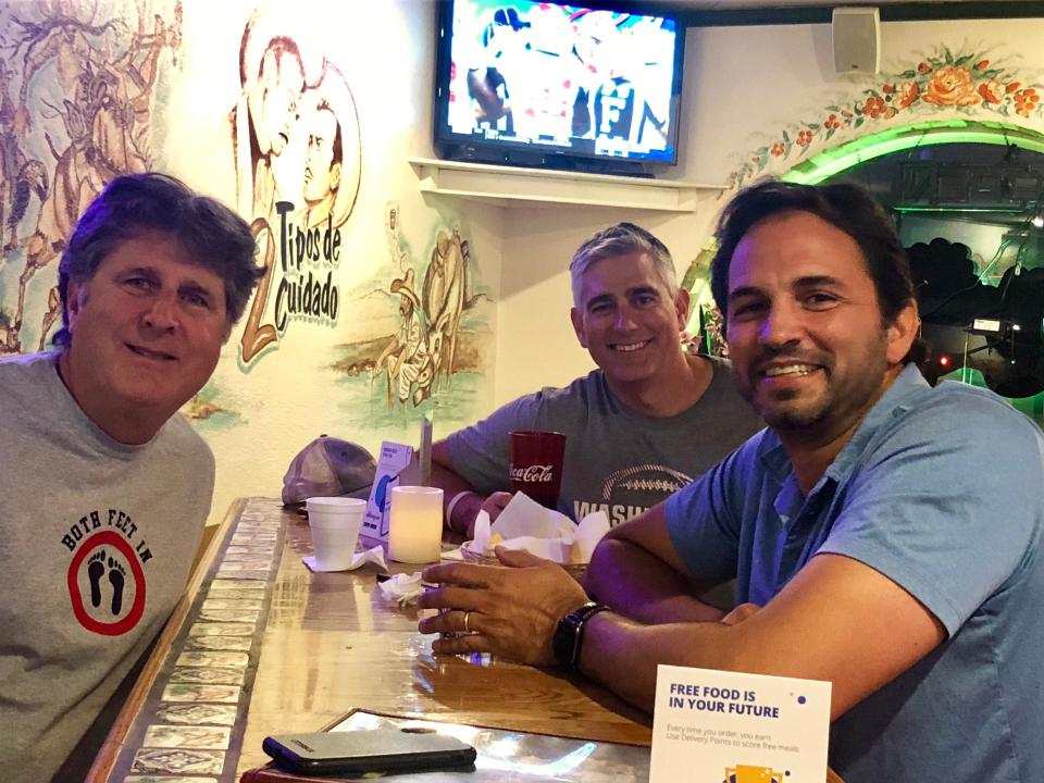 Mike Leach, left, dines with friends Michael Baumgartner, center, and Ferhat Guven in 2019 in Pullman, Washington, while discussing Washington State's quarterback competition.