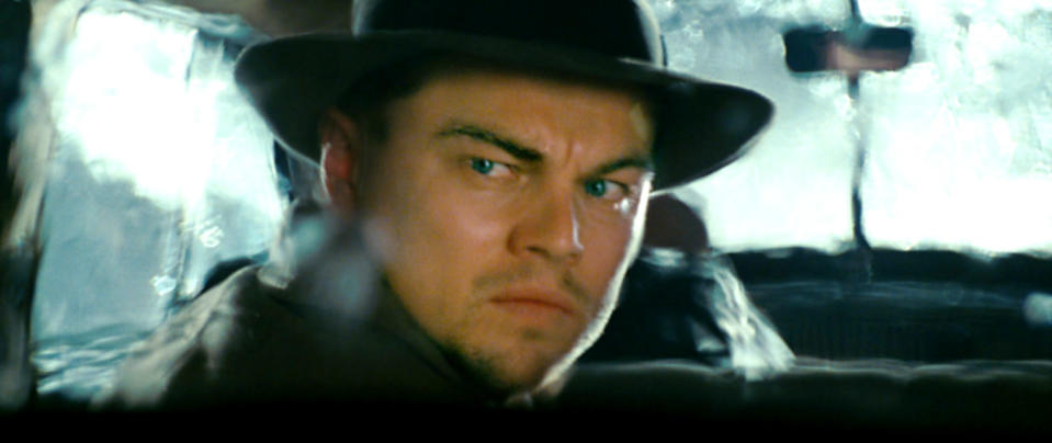 Leonardo DiCaprio looking behind him in a car