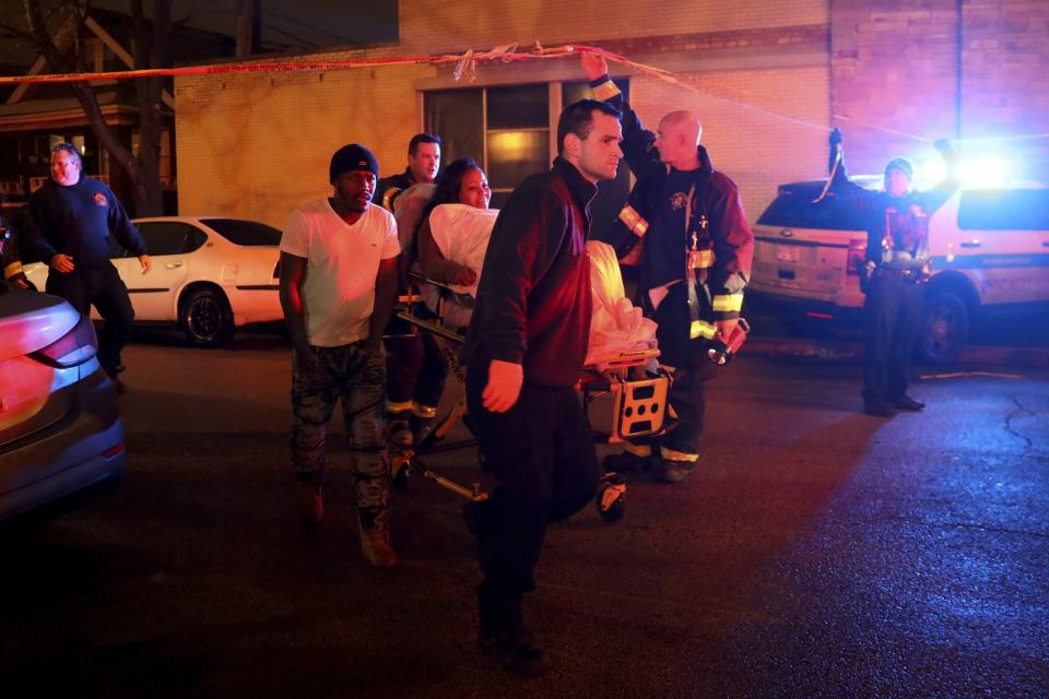 A woman who was shot is taken to an ambulance by members of the Fire Department at the scene where at least six people were shot, one fatally, on the 8600 block of South Maryland Avenue on Dec. 25, 2016 in Chicago. (Photo: Armando L. Sanchez/Chicago Tribune/TNS via Getty Images)