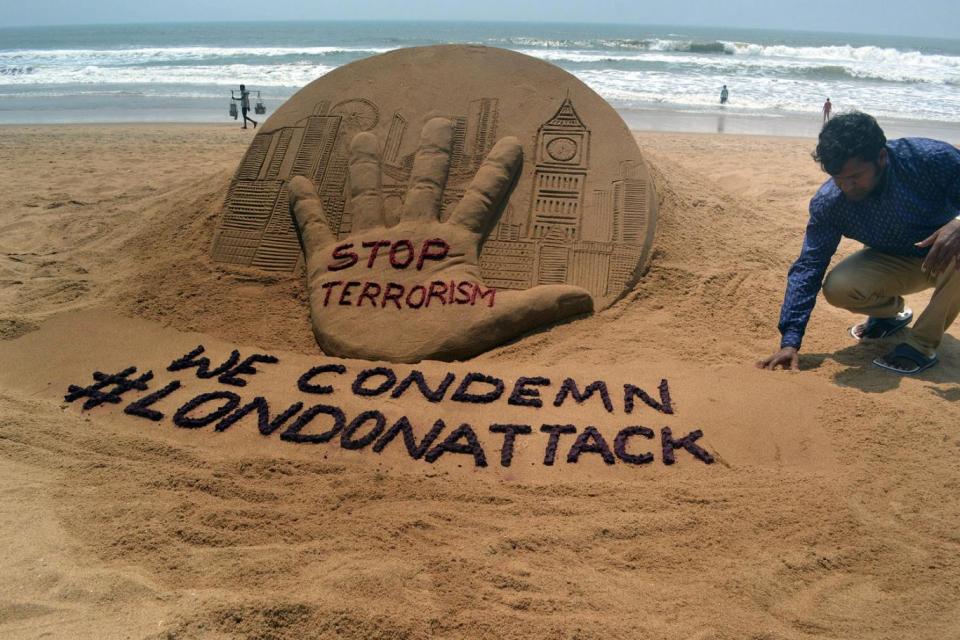 Indian sand artist finishing sculpture condemning the terrorist attack (EPA)