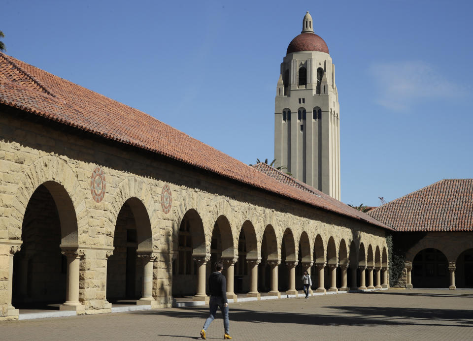 FILE - People walk on the Stanford University campus beneath Hoover Tower in Stanford, Calif., on March 14, 2019. The president of Stanford University Marc Tessier-Lavigne said Wednesday, July 19, 2023, he would resign, citing an independent review that cleared him of research misconduct but found flaws in other papers authored by his lab. Tessier-Lavigne said in a statement to students and staff that he would step down August 31. (AP Photo/Ben Margot, File)