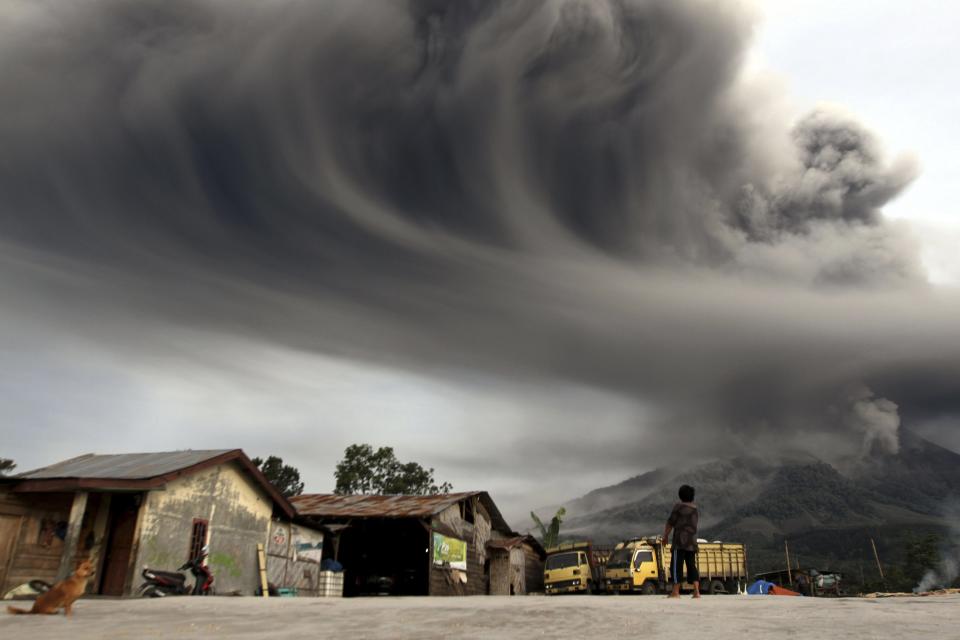 RNPS - PICTURES OF THE YEAR 2013 - A woman looks on as Mount Sinabung spews ash, as pictured from Sibintun village in Karo district, Indonesia's north Sumatra province November 18, 2013. Mount Sinabung continued to spew volcanic ash throwing a plume 8,000 meters into the atmosphere as thousands of residents remained in temporary shelters fearful of more eruptions, according to local media. REUTERS/Roni Bintang (INDONESIA - Tags: DISASTER ENVIRONMENT TPX)