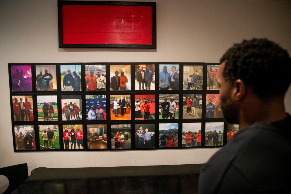 Melvin Cole, founder of PURE Academy, looks at a wall of photos showing when college athletes, coaches and other people met with Cole and the students either at the academy or when he and his students did college tours while giving a tour of the academy in Memphis, Tenn., on Tuesday, March 26, 2024.