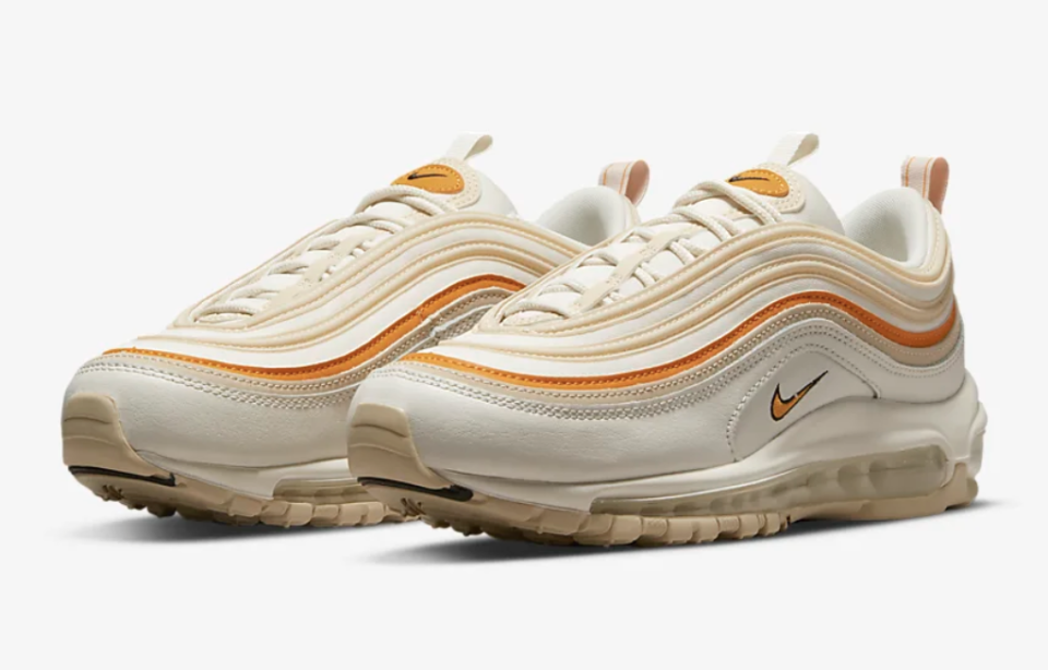 Tan shoes with orange ripple lines and Nike swoosh.