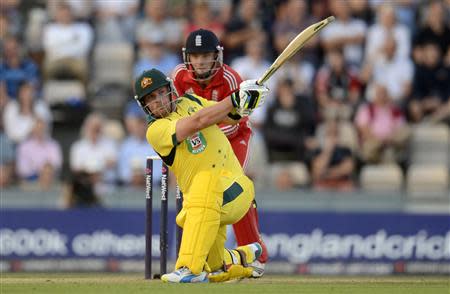 Australia's Aaron Finch (L) hits out watched by England's Jos Buttler during the first T20 international at the Rose Bowl cricket ground, Southampton August 29, 2013. REUTERS/Philip Brown