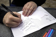 Kara McKlemurry writes Thanksgiving notes to family and friends at her home Thursday, Nov. 19, 2020, in Clearwater, Fla. On any normal Thanksgiving Day, McKlemurry and her husband would drive from their home to one of two places: his family's home in another part of Florida or her family's house in Alabama. This year, McKlemurry informed her family there would be no visits because of the pandemic.(AP Photo/Chris O'Meara)