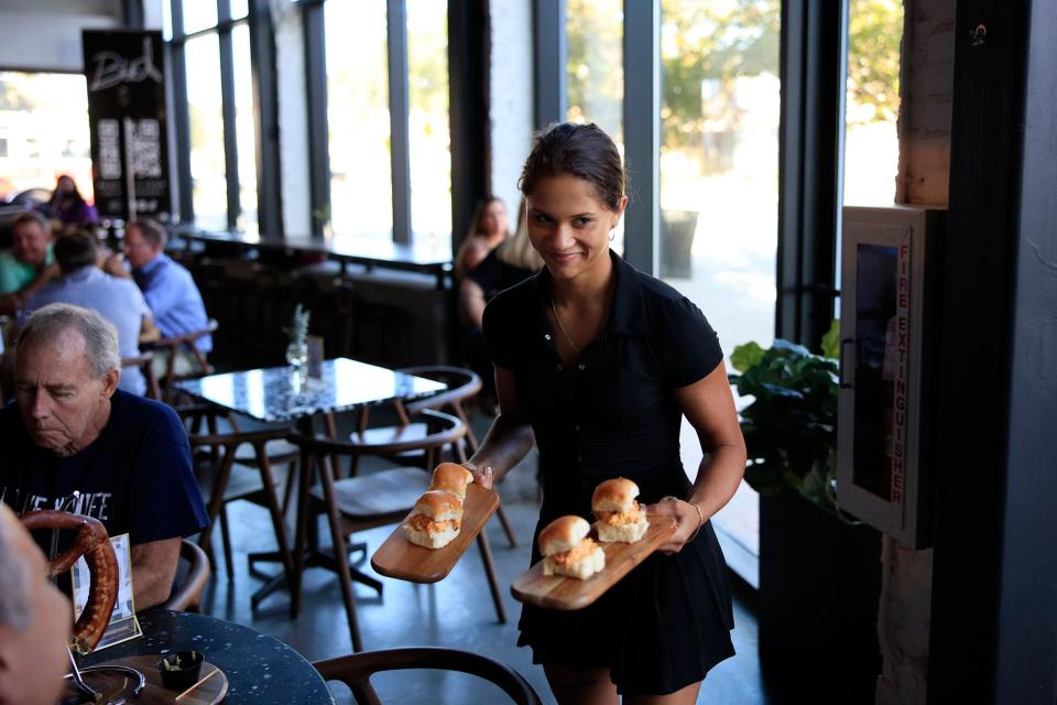 Lexi Mayzak serves slider sandwiches at Fore Score Golf Tavern on San Marco Square in Jacksonville.