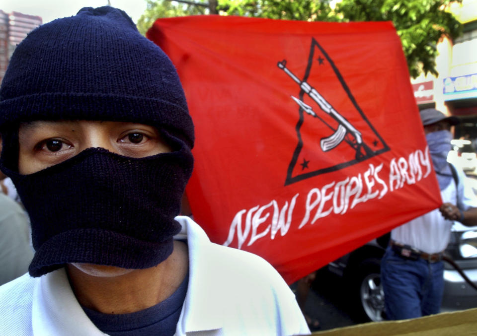 FILE - A masked protester joins a rally on the commemoration of the 36th anniversary of the Communist Party of the Philippines, New People's Army, in a busy shopping district in Manila on Sunday Dec. 26, 2004. The Philippine government and the country’s communist rebels have agreed to resume talks aimed at ending decades of armed conflict, one of Asia's longest, Norwegian mediators announced Tuesday, Nov. 28, 2023. (AP Photo/Aaron Favila, File)