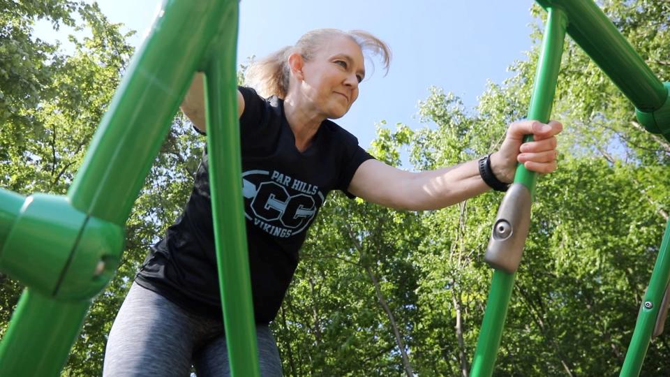 Breast-cancer survivor, Parsippany Hills track coach and triathlete Michelle Perry works on upper-body strength by climbing aluminum bars at a playground near her Rockaway home. It is part of her workout for the Summit Challenge obstacle course fundraiser on June 5.