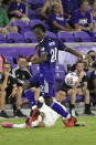 Orlando City midfielder Andres Perea (21) and Atlanta United defender Ronald Hernandez, below, compete for the ball during the second half of an MLS soccer match Friday, July 30, 2021, in Orlando, Fla. (Phelan M. Ebenhack/Orlando Sentinel via AP)