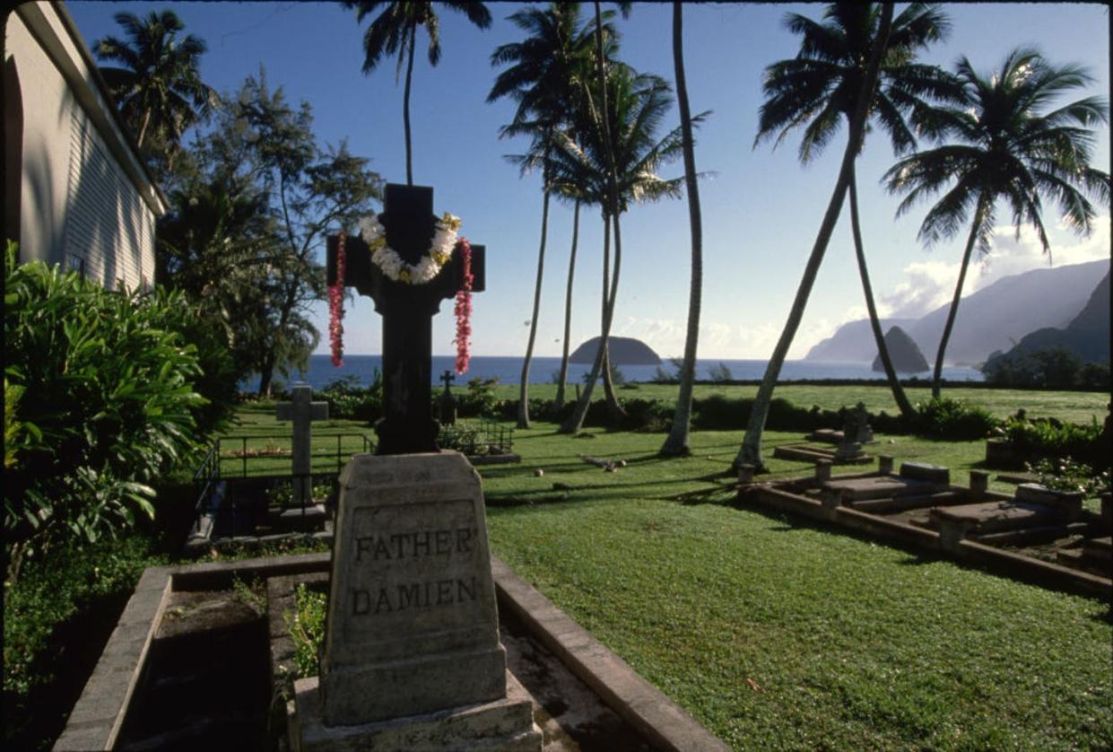 <span class="caption">The headstone of Father Damien, a Catholic saint who was canonized in 2009.</span> <span class="attribution"><a class="link " href="https://www.gettyimages.com/detail/news-photo/news-photo/1081384530?adppopup=true" rel="nofollow noopener" target="_blank" data-ylk="slk:Richard A. Cooke III/Corbis Historical via Getty Images;elm:context_link;itc:0;sec:content-canvas">Richard A. Cooke III/Corbis Historical via Getty Images</a></span>