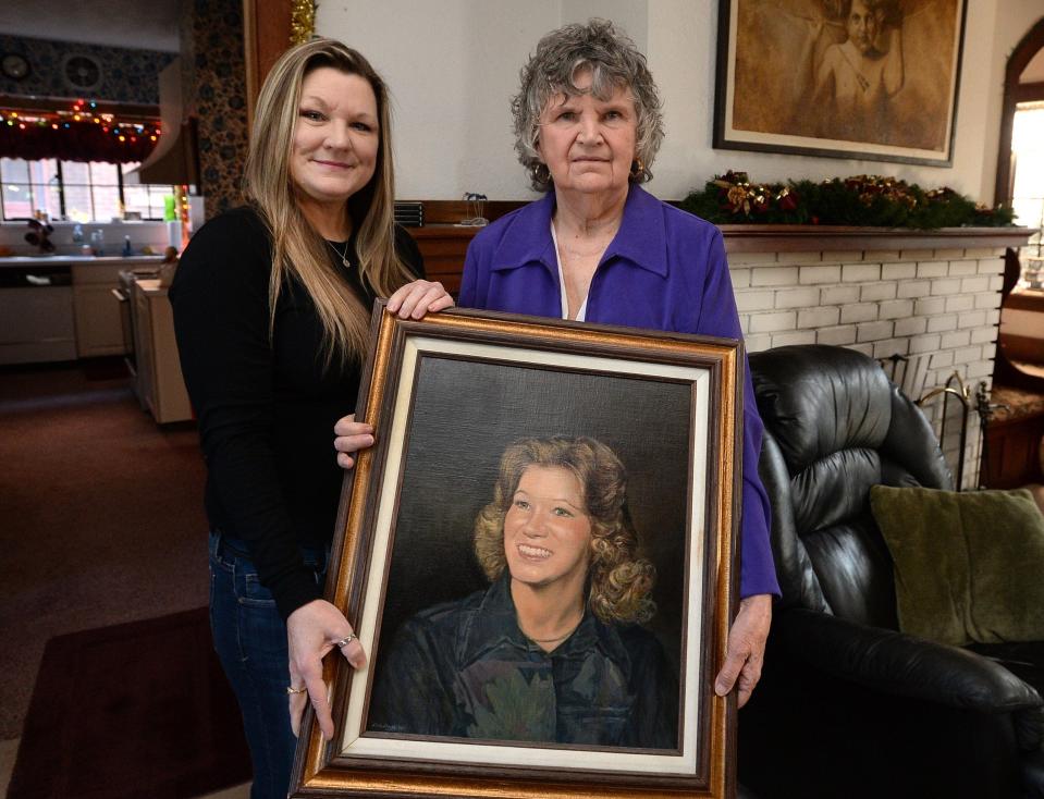 Myshelle Will, left, and her mother Betty Ferguson are shown with a portrait of Ferguson's deceased daughter, Debbie Gama, in January 2019 at Ferguson's Erie home.