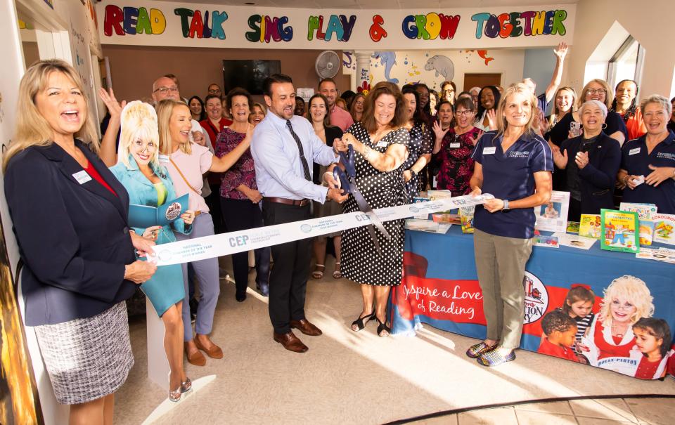 Ocala Mayor Ben Marciano, center left with scissors, helps Early Learning Coalition of Marion County CEO Carrie Theall, center right, with ribbon cutting for the Dolly Parton’s Imagination Library at the ELCMC Thursday morning April 25, 2024.