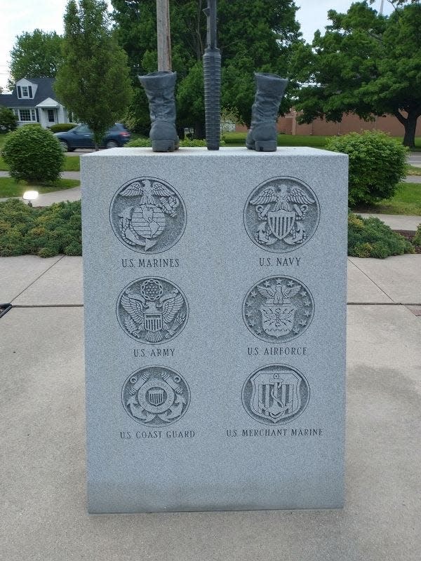 The rear view of the War on Terrorism Memorial shows images of the six military branches of the United States military: Marines, Navy, Army, Air Force, Coast Guard, and Merchant Marine.