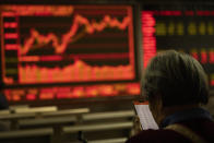 In this Thursday, Dec. 12, 2019, photo, an investor monitors stock prices at a brokerage in Beijing. Shares likewise jumped Friday, Dec. 13, 2019 in Asia following fresh all-time highs overnight on Wall Street spurred by optimism that the U.S. and China are close to reaching a deal to end their costly trade war. (AP Photo/Ng Han Guan)