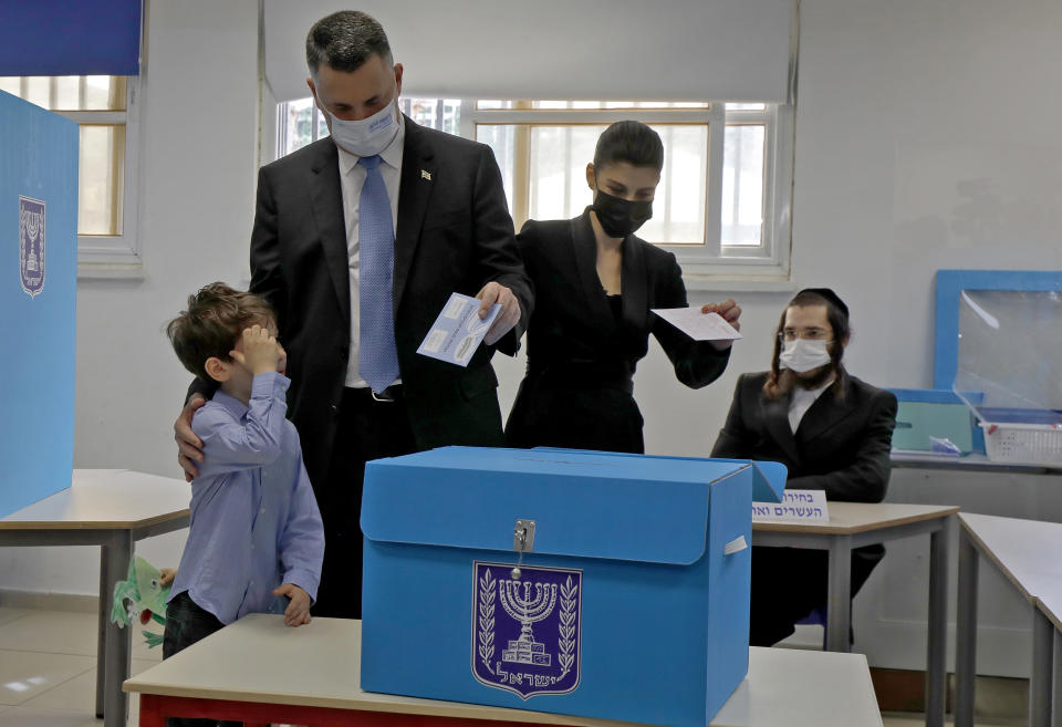 Chairman of Israel's New Hope party Gideon Saar and his wife Geula vote with their children at a polling station during Israel's fourth national election in the coastal city of Tel Aviv Tuesday, March 23, 2021. Israelis began voting on Tuesday in the country's fourth parliamentary election in two years, a highly charged referendum on the divisive rule of Prime Minister Benjamin Netanyahu. (Jalaa Marey/Pool Photo via AP)