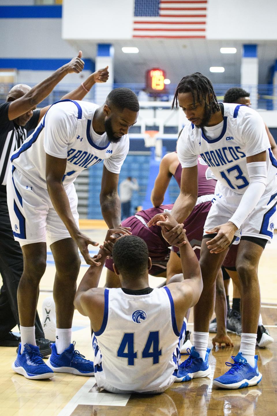 Broncos teammates D'Marco Baucum (1) and Tyler Foster (13) help Caleb Simmons to his feet during the Virginia Union at Fayetteville State men’s basketball game on Thursday, Jan. 11, 2024.