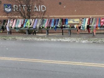 Scarves hang on the fence at Rite Aid in New Philadelphia, the first distribution location for the Scarf Project founded and organized by Toni Kaltenbaugh.