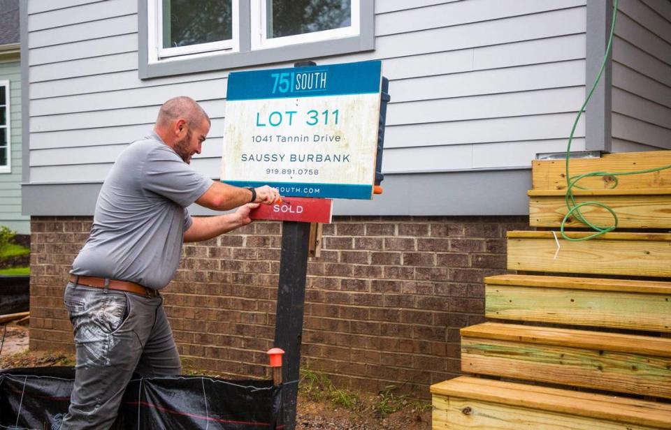 Mike Burns, construction manager for the building company Saussy Burbank, secures a “sold” sign to a home in 751 South, a development in Durham, N.C., on Friday, Sept. 25, 2020.