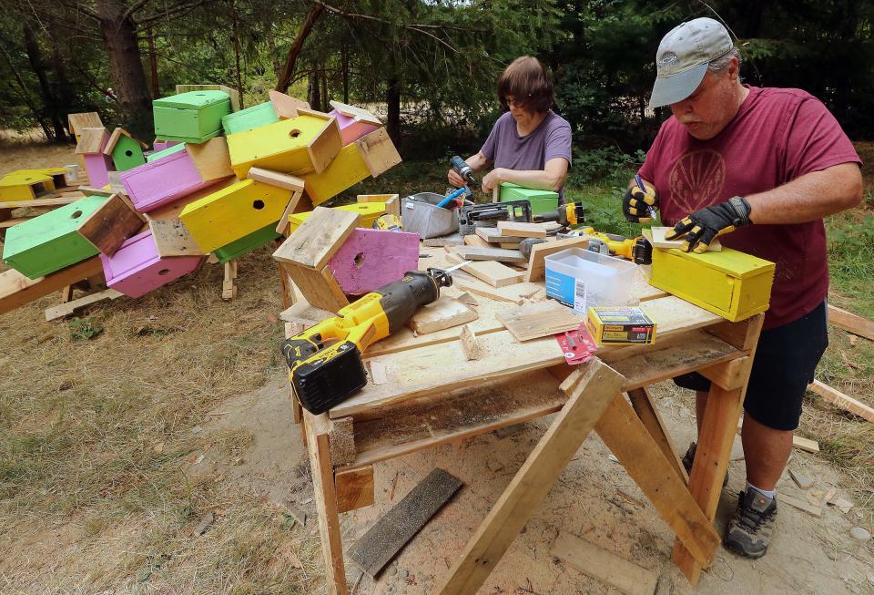 Volunteers Wendy Greenberg, left, and Brad Lozowski, both of Bainbridge Island, build birdhouses that will be a part of Artist Thomas Dambo's "Pia the Peacekeeper" troll installation in Sakai Park on Bainbridge Island, Wash. on Friday, Aug. 18, 2023.