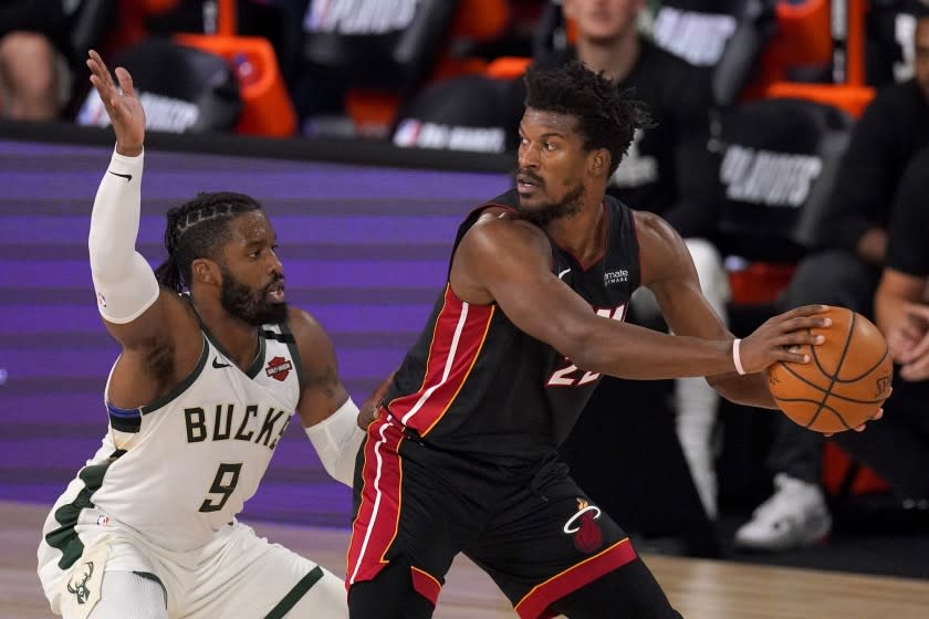 Milwaukee Bucks' Wesley Matthews (9) defends as Miami Heat's Jimmy Butler (22) handles the ball during the second half of an NBA basketball conference semifinal playoff game, Monday, Aug. 31, 2020, in Lake Buena Vista, Fla. (AP Photo/Mark J. Terrill)