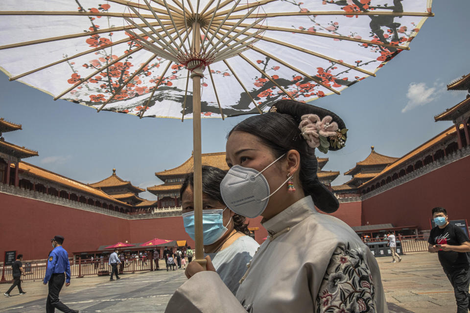 Women wearing protective face masks walk past the entrance to the Forbidden City on the first day of China's National People's Congress (NPC) in Beijing, China, Friday, May 22, 2020. (Roman Pilipey/Pool Photo via AP)