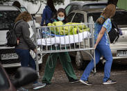 Health workers evacuate a child patient from a fire inside a San Borja Arrarian hospital in Santiago, Chile, Saturday, Jan. 30, 2021. Authorities have not reported deceased or injured patients. (AP Photo/Esteban Felix)