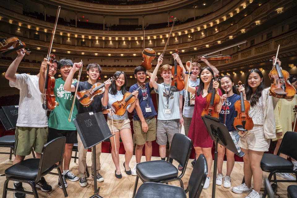 This image provided by the Carnegie Hall shows the National Youth Orchestra of the USA. Teenaged musicians from the National Youth Orchestra of the USA walked onto the Carnegie Hall stage before rehearsal and had a uniform reaction, much like string sections following their leaders: They pulled out cell phones and took selfies. Carnegie Hall's initiative to train the next generation turned 10 this year. (Chris Lee/Carnegie Hall via AP)