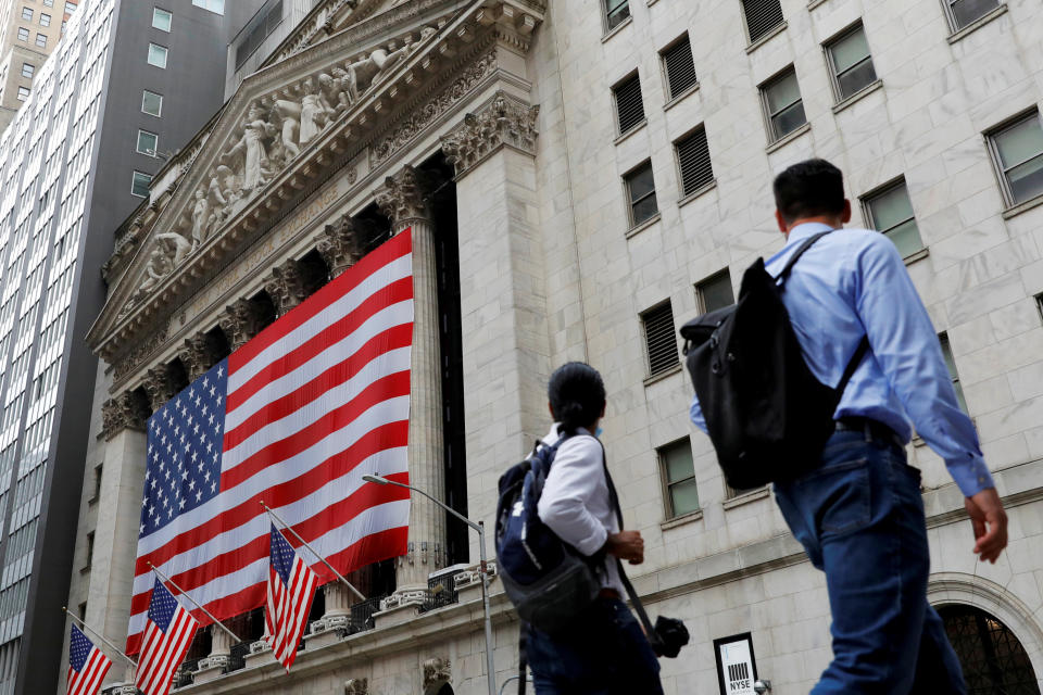 FILE PHOTO: People walk by the New York Stock Exchange (NYSE) in Manhattan, New York City, U.S., August 9, 2021. REUTERS/Andrew Kelly/File Photo