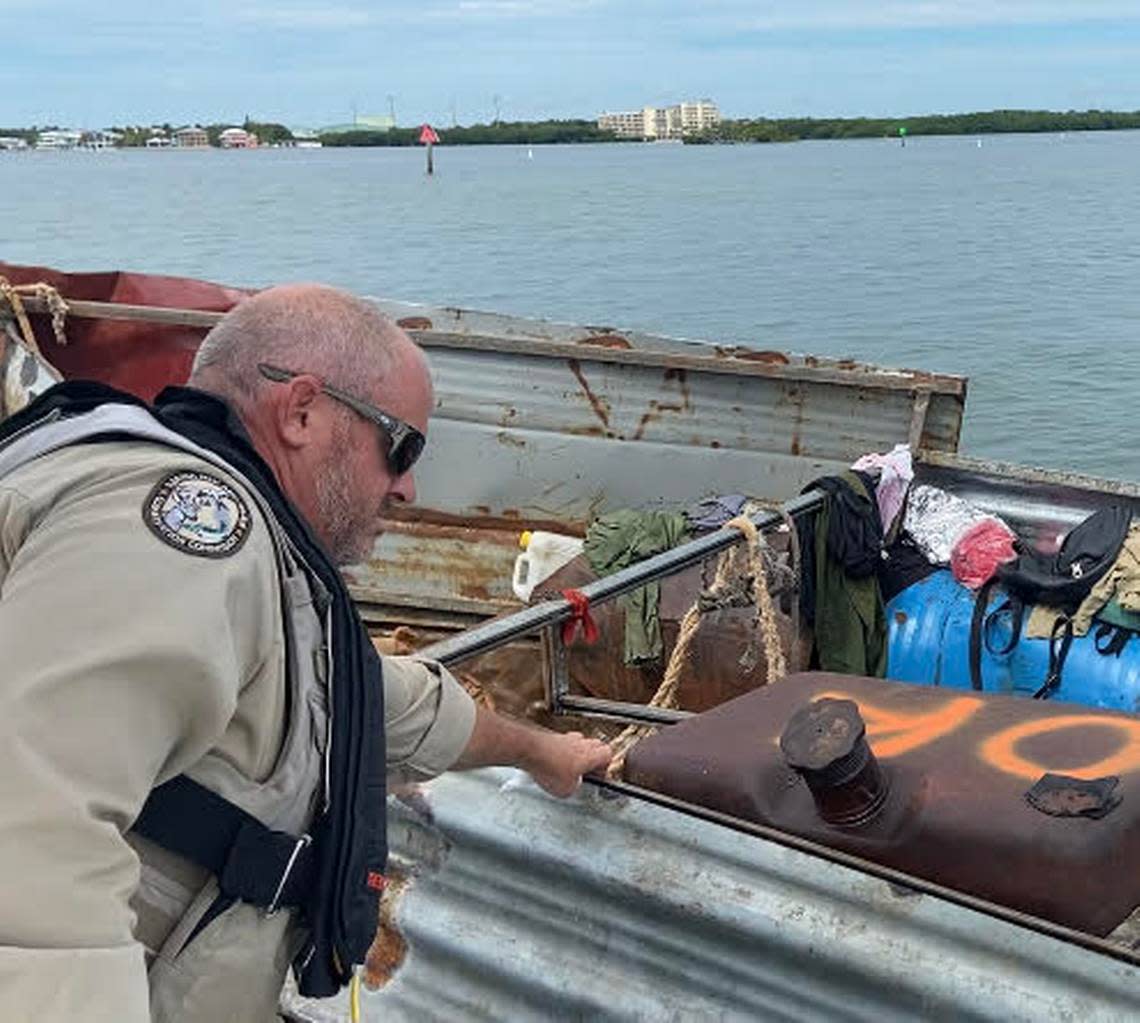 Florida Fish and Wildlife Conservation Commission Officer Jason Rafter inspects a Cuban boat floating on the ocean side of Tavernier Creek in the Florida Keys Friday, Oct. 14, 2022.