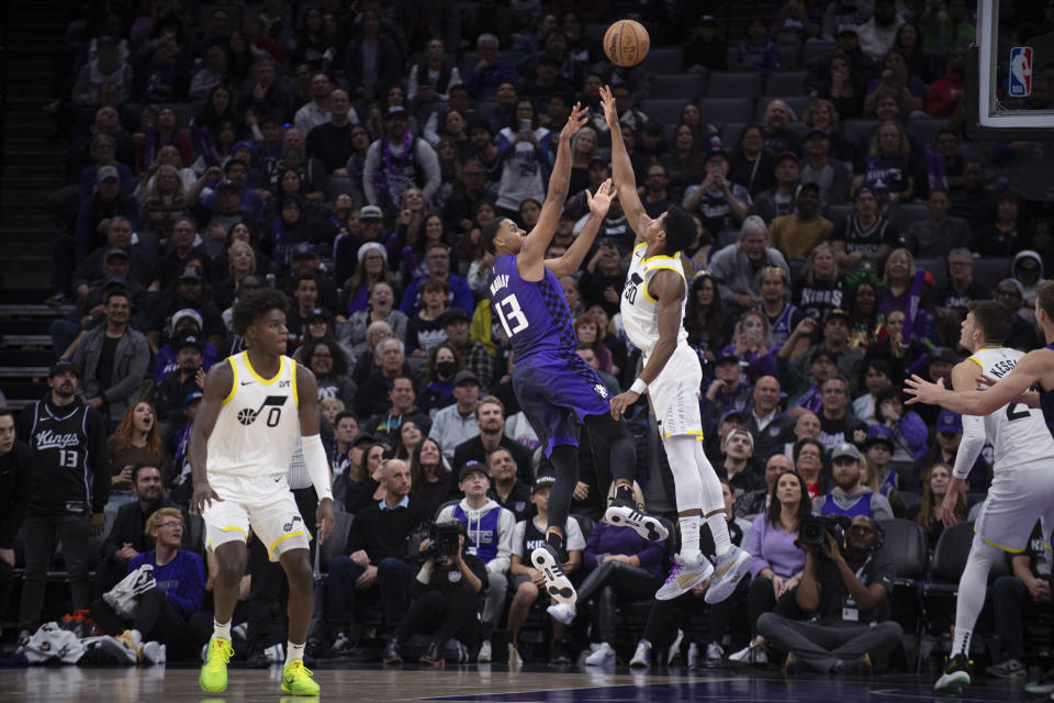 Sacramento Kings forward Keegan Murray (13) scores over Utah Jazz guard Ochai Agbaji during the second half of an NBA basketball game in Sacramento, Calif., Saturday, Dec. 16, 2023. (AP Photo/José Luis Villegas)