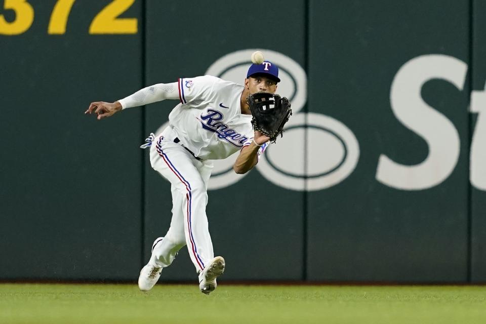 Texas Rangers left fielder Bubba Thompson reaches out to catch an RBI sacrifice fly hit by Houston Astros' Alex Bregman during the first inning of a baseball game in Arlington, Texas, Tuesday, Aug. 30, 2022. (AP Photo/Tony Gutierrez)