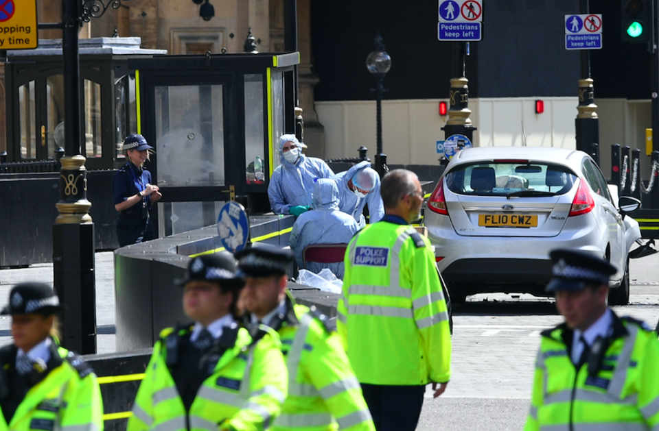 <em>Officers and forensic teams stand by the car that crashed into security barriers (PA)</em>