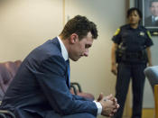 Former Cleveland Browns quarterback Johnny Manziel sits at the back of the courtroom while his defense attorneys confer with the prosecution during his initial hearing, May 5, 2016, in Dallas. The Heisman Trophy winner and former Texas A&M star was indicted by a grand jury last month after his ex-girlfriend alleged he hit her and threatened to kill her during a night out in January. No plea was entered, but defense attorney Robert Hinton says Manziel plans to plead not guilty. (Smiley N. Pool/The Dallas Morning News via AP)