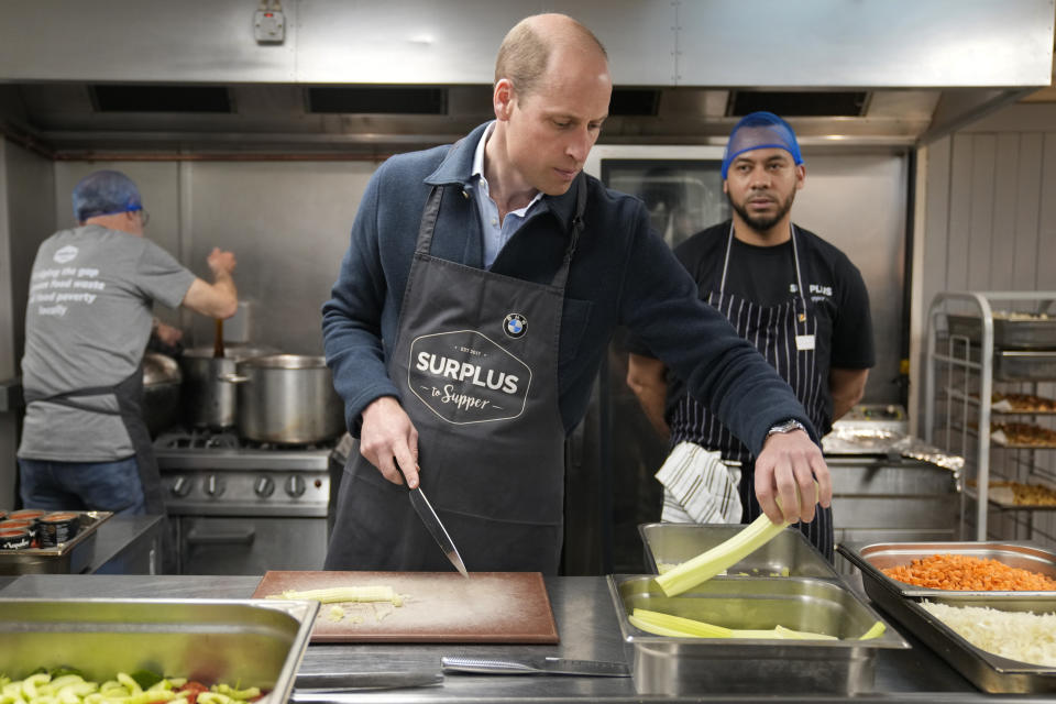 Britain's Prince William cuts celery as he helps to make a bolognase sauce during a visit to Surplus to Supper, in Sunbury-on-Thames, Surrey, England, Thursday, April 18, 2024. The Prince visited Surplus to Supper, a surplus food redistribution charity, to learn about its work bridging the gap between food waste and food poverty across Surrey and West London. (AP Photo/Alastair Grant, pool)