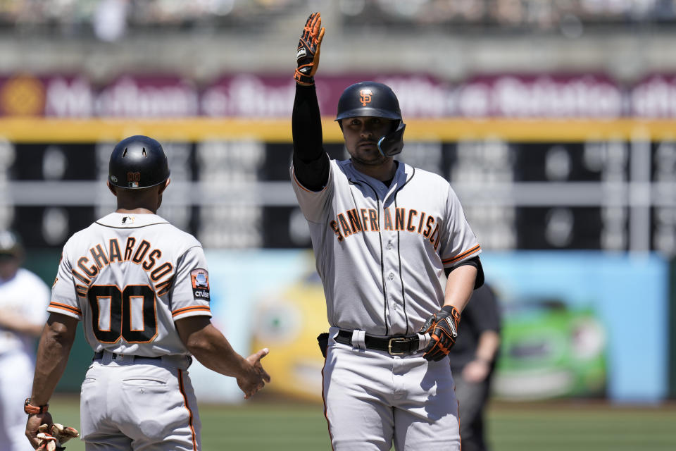 San Francisco Giants' J.D. Davis, right, reacts after hitting an RBI single against the Oakland Athletics during the first inning of a baseball game Sunday, Aug. 6, 2023, in Oakland, Calif. (AP Photo/Godofredo A. Vásquez)