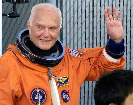 Astronaut John Glenn waves with crewmates as they depart crew quarters for the launching pad at the Kennedy Space Centre October 29, 1998. REUTERS/File Photo