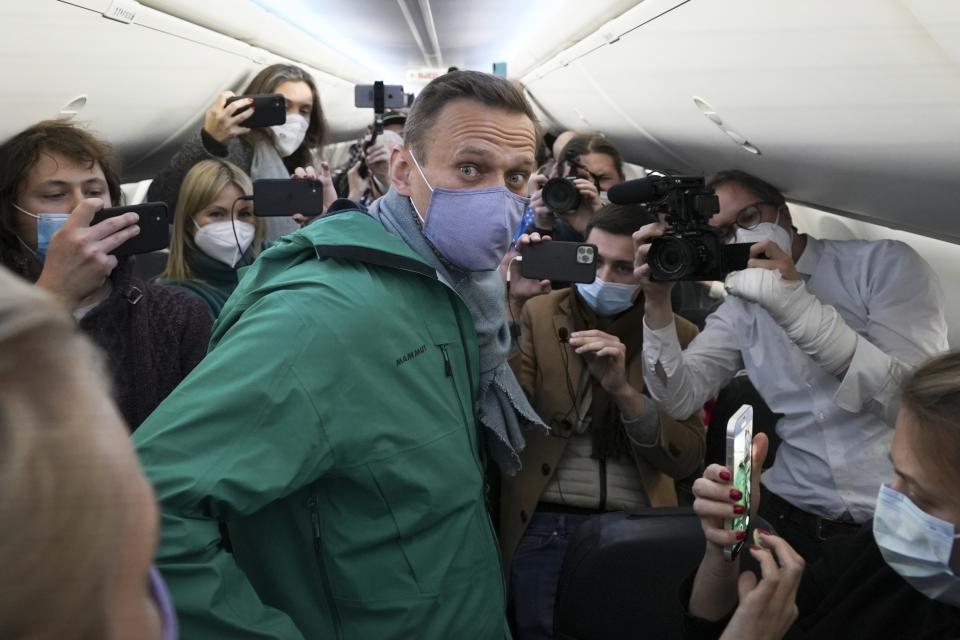 FILE - Alexei Navalny is surrounded by journalists inside the plane prior to his flight to Moscow in the Airport Berlin Brandenburg (BER) in Schoenefeld, near Berlin, Germany, on Jan. 17, 2021. Navalny is arrested at a Moscow airport as he returns from Germany. He is later convicted on several charges and sentenced to 19 years in prison. (AP Photo/Mstyslav Chernov, File)