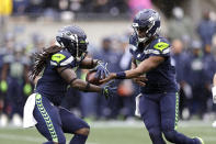 Seattle Seahawks quarterback Geno Smith, right, hands off to running back Alex Collins during the first half of an NFL football game against the New Orleans Saint, Monday, Oct. 25, 2021, in Seattle. (AP Photo/John Froschauer)