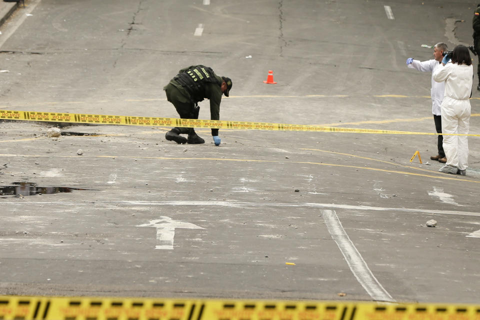 CORRECTS TO TWO DOZEN POLICE OFFICERS INJURED AND NO DEATHS - Police and investigators inspect the site where a homemade bomb exploded near the Santamaria bull ring in Bogota, Colombia, Sunday, Feb. 19, 2017. The artefact was detonated just a few hours before a scheduled bullfight, as police in riot gear were congregating ahead of a demonstration by animal rights activists. An official police statement said that 26 people suffered shrapnel and blast injuries, all but two of them officers. (AP Photo/Ricardo Mazalan)