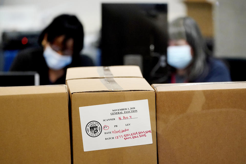 Maricopa County elections officials count ballots behind boxes of counted ballots, Wednesday, Nov. 4, 2020, at the Maricopa County Recorders Office in Phoenix. (AP Photo/Matt York)