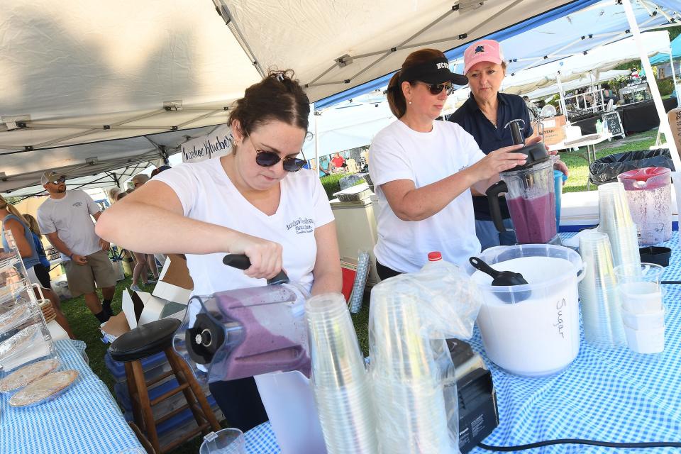 Gracie Eakins, Jessica Andrews and Angela Moore with Ivanhoe Blueberry Farms make some blueberry smoothies during the North Carolina Blueberry Festival in Burgaw, N.C. Saturday June 18, 2022. KEN BLEVINS/STARNEWS