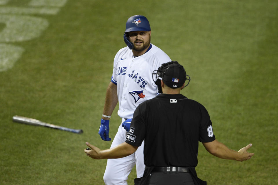 Toronto Blue Jays' Rowdy Tellez, back, has words with home plate umpire umpire Stu Scheurwater, front, after he was ejected and called out on strikes during the tenth inning of a baseball game against the Washington Nationals, Wednesday, July 29, 2020, in Washington. The Nationals won 4-0 in extra innings. (AP Photo/Nick Wass)