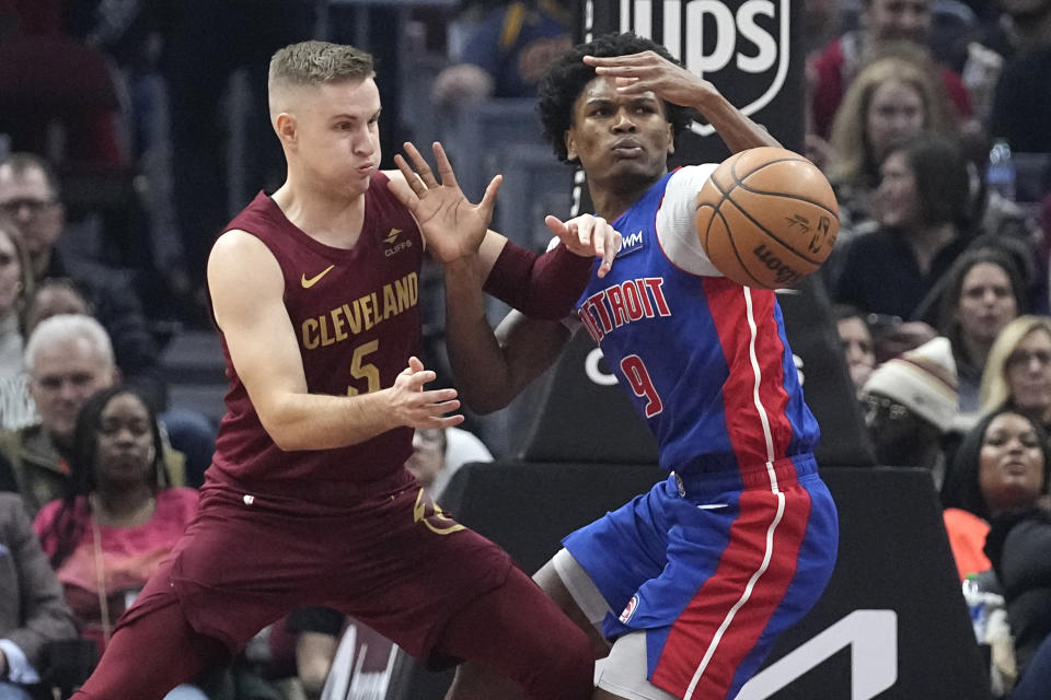 Cleveland Cavaliers guard Sam Merrill, left, knocks the ball away from Detroit Pistons forward Ausar Thompson (9) in the first half of an NBA basketball game, Wednesday, Jan. 31, 2024, in Cleveland. (AP Photo/Sue Ogrocki)