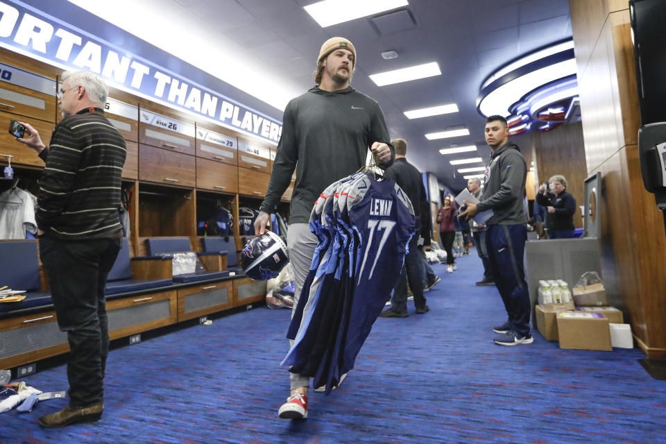 Tennessee Titans offensive tackle Taylor Lewan, center, gathers items as players clean out their lockers Monday, Jan. 20, 2020, in Nashville, Tenn. The Titans lost the AFC Championship NFL football game Sunday to the Kansas City Chiefs. (AP Photo/Mark Humphrey)