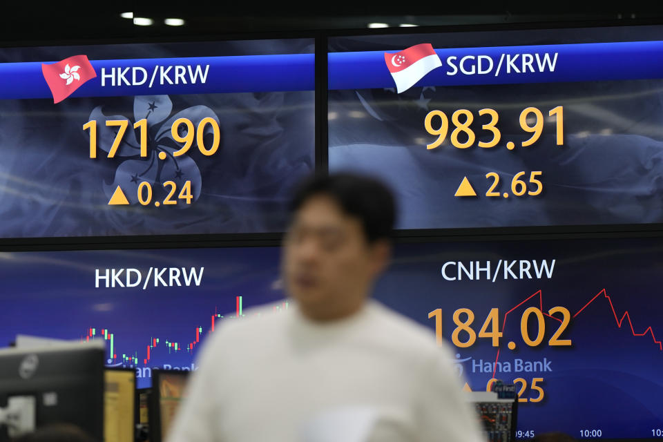 A currency trader walks by the screens showing the foreign exchange rates at a foreign exchange dealing room in Seoul, South Korea, Wednesday, Oct. 25, 2023. Asian shares advanced Wednesday, tracking gains on Wall Street after Verizon and other big companies reported fatter profits for the summer than expected. (AP Photo/Lee Jin-man)